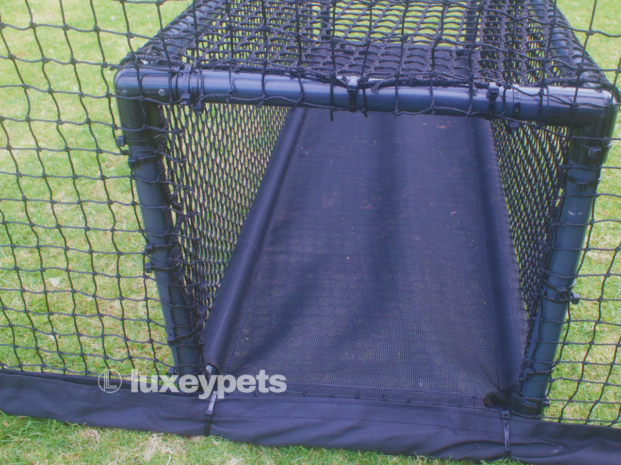 Black pet playpen with a mesh door on a grassy background