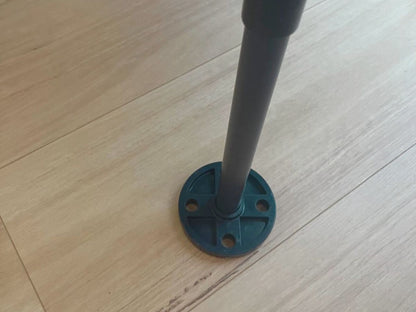 Black and blue pipe fitting on a wooden floor