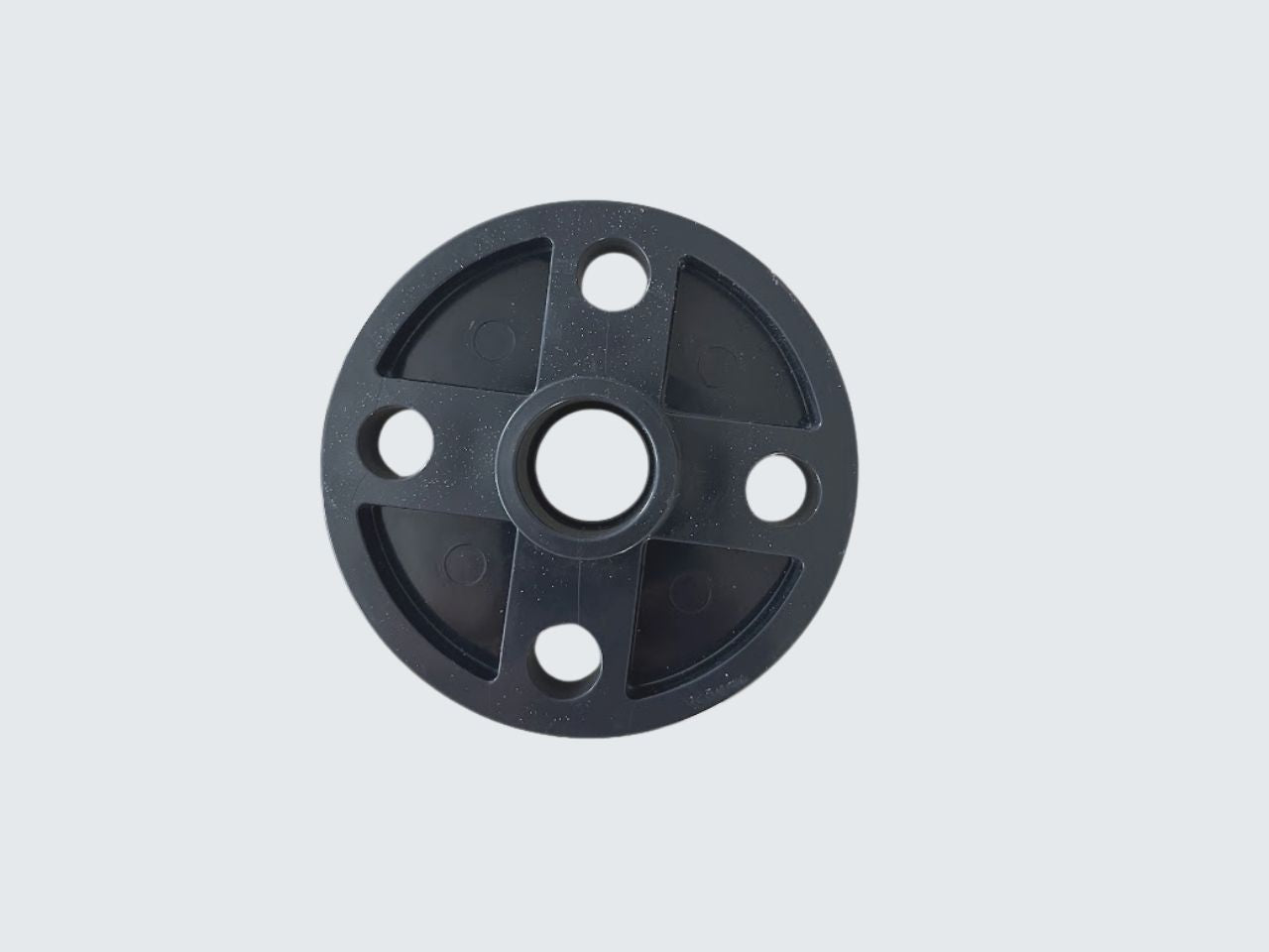 Black circular mechanical part on a light gray background